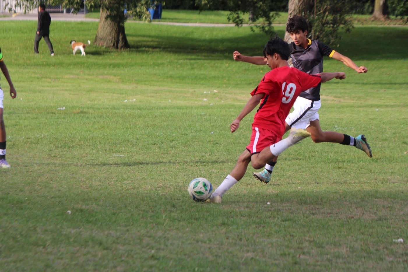 A Dixon FC player, number 19, dribbles past a defender